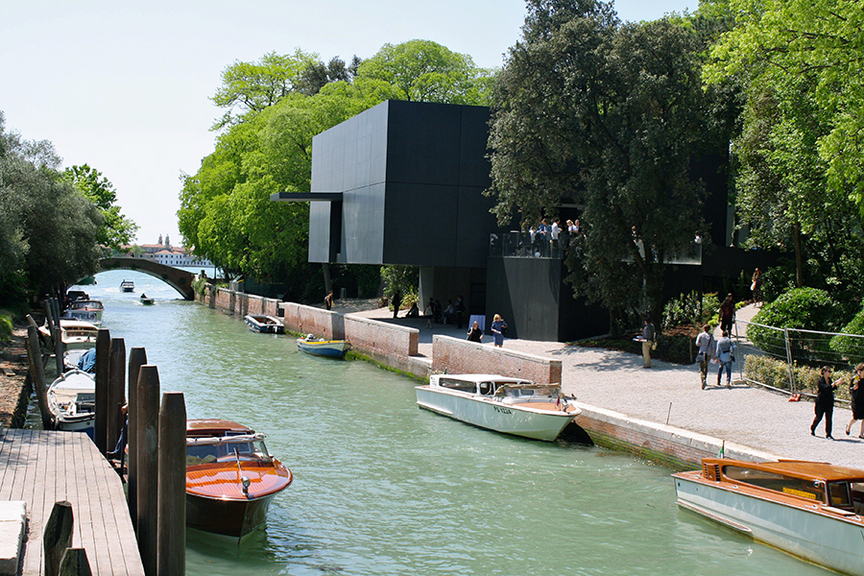 The new Australia Pavilion, seen here from the Rio del Giardini that bisects the gardens, was designed by Denton Corker Marshall. Meant to be contemporary and sophisticated, the solid black box with a white-cube interior (repleted with concrete floors) draws comparisons to a blue-chip art gallery or a design hotel. Fortunately, the old building—which hosted 13 art biennales—was repatriated to Australia, and the new structure provides much needed facilities (a restroom and storage areas), plus solar panels on the roof.