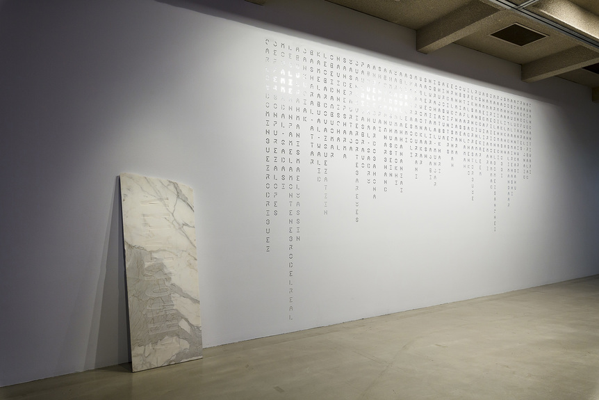 Installation view of EUGENIA RASKOPOULOS’s (left) In a word untitled #1, 2004, marble, 193.5 × 71.5 × 3 cm; and (right) Un(truth), 2019, reflective vinyl, 578 × 358.5 cm, at “OK Democracy, We Need to Talk,” Campbelltown Arts Centre, Sydney, 2019.