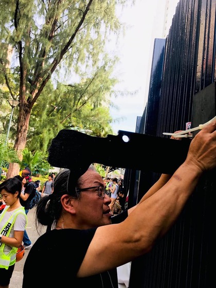 SANMU CHAN was held by mainland police for seven hours over his participation in recent Hong Kong protests. On July 27, he put up wooden “thumbs-down” sculptures outside Yuen Long Police Station. All images via Sanmu Chan’s Facebook.