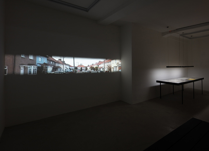 Installation view of PREM SAHIB’s (left) Cul-de-Sac, 2019, HD video projection on loop: 5 min 58 sec; and (right) Archive, 2019, wood, painted steel, acrylic, archival material belonging to Kamaljit Sahib, at “Descent II. Cul-de-Sac,” Southard Reid, London, 2019. Photo by Lewis Ronald.